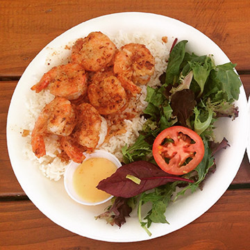 Shrimp, rice, and salad on a plate.