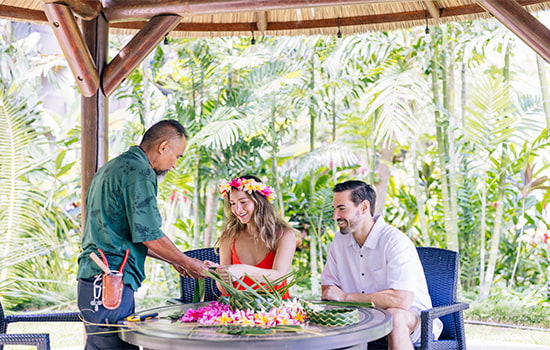 Couple learning how to make leis.