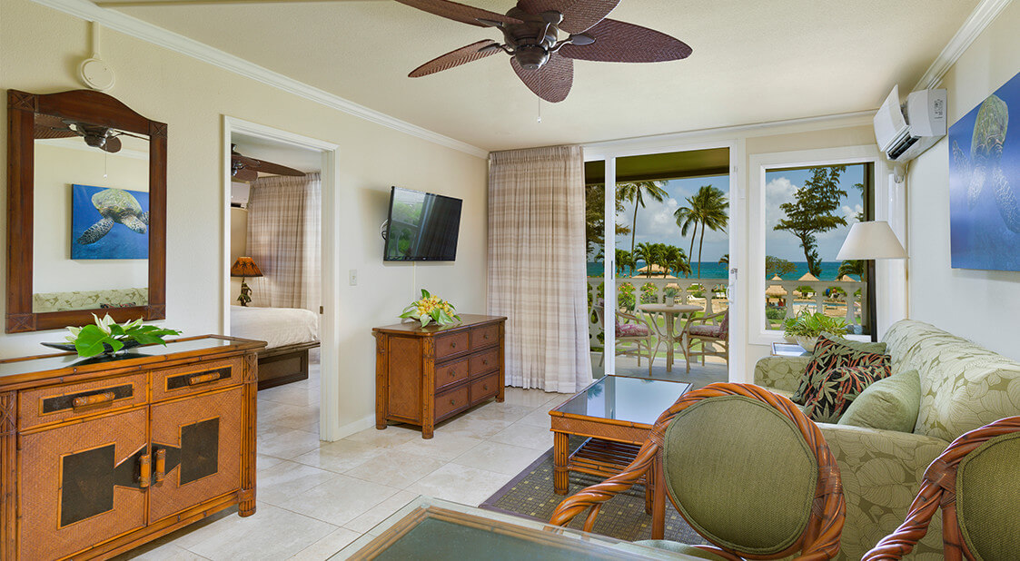 Living room with a couch, coffee table, TV, and balcony.