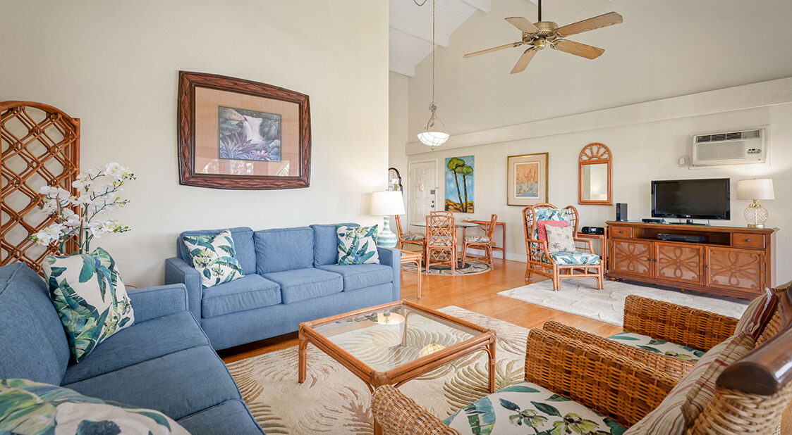 Living room with a couch, coffee table, dining area, and TV.