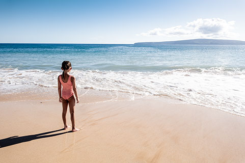 Kid on the beach looking out 