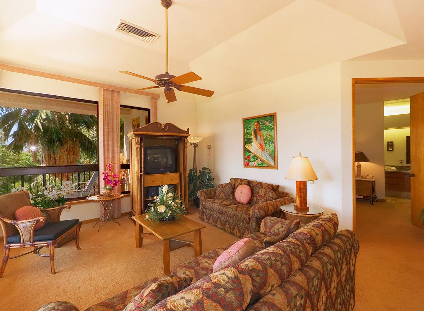 Living area with couch, table, TV, balcony