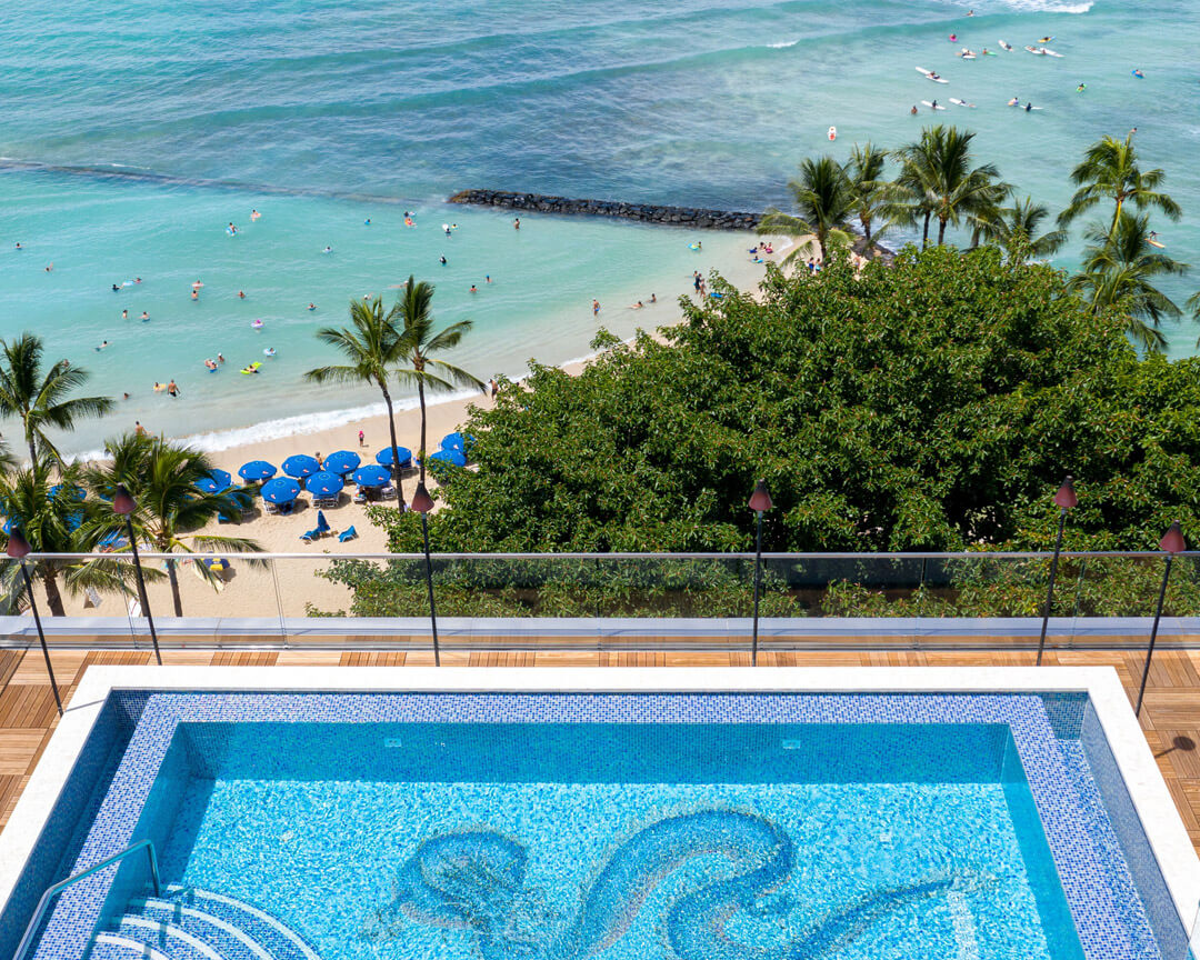 View of rooftop swimming pool overlooking Waikiki Beach.