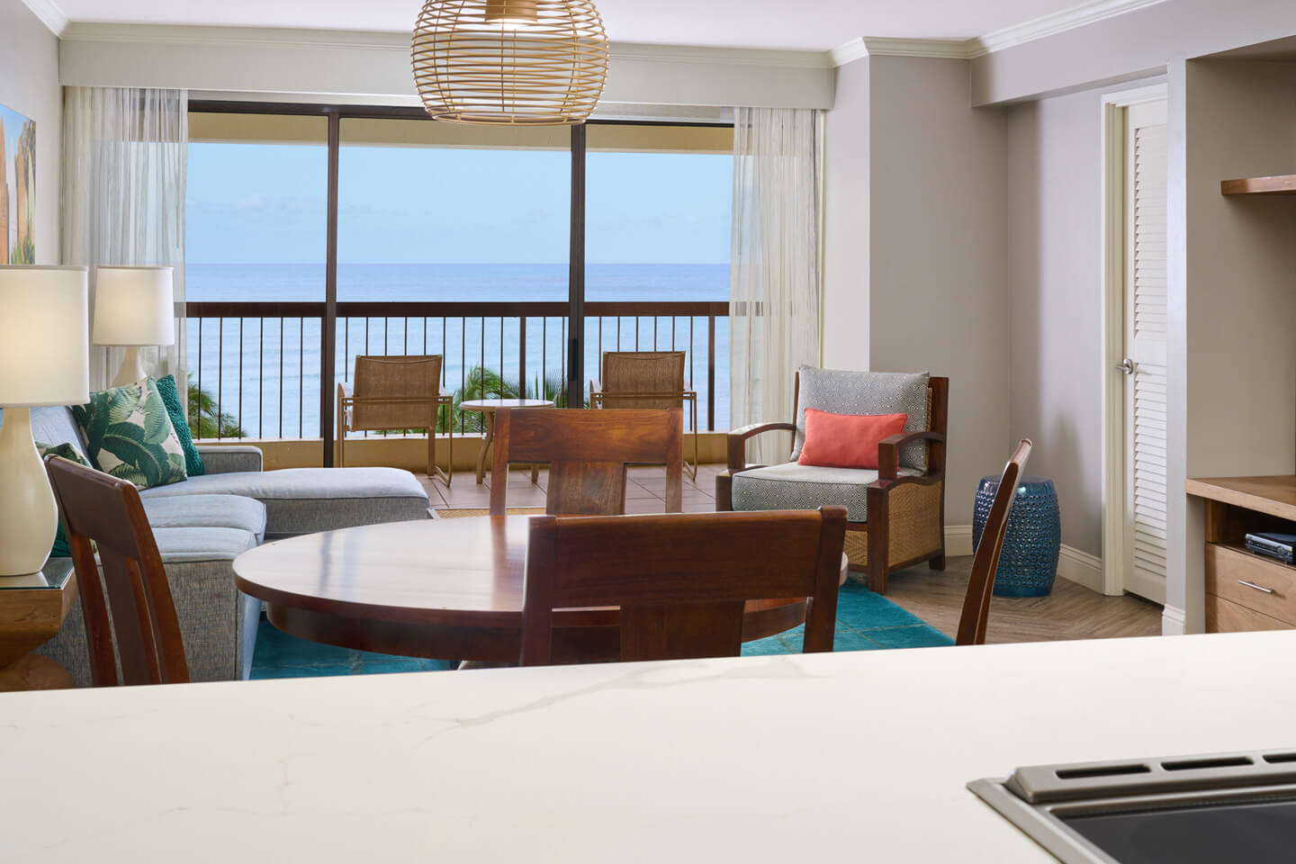 Living room with ocean view and large windows opening onto a patio.