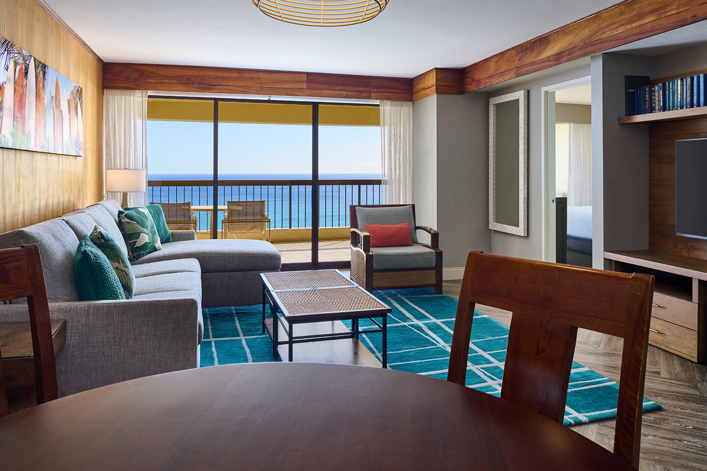 Living room with ocean view and large windows opening onto a balcony.