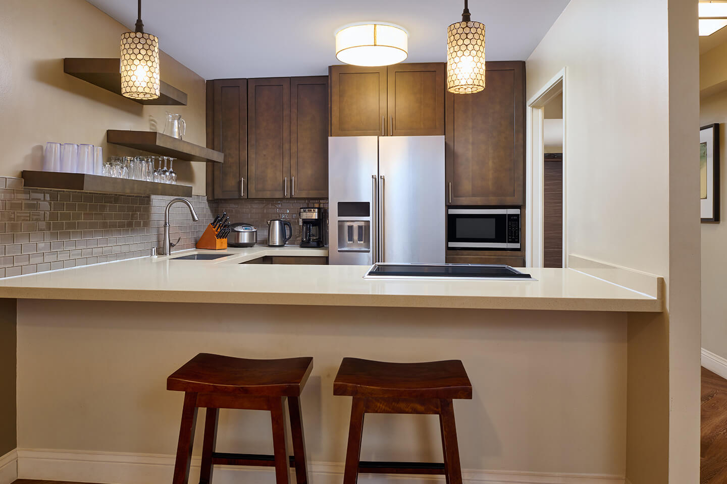 Fully equipped kitchen with two barstools at a counter.