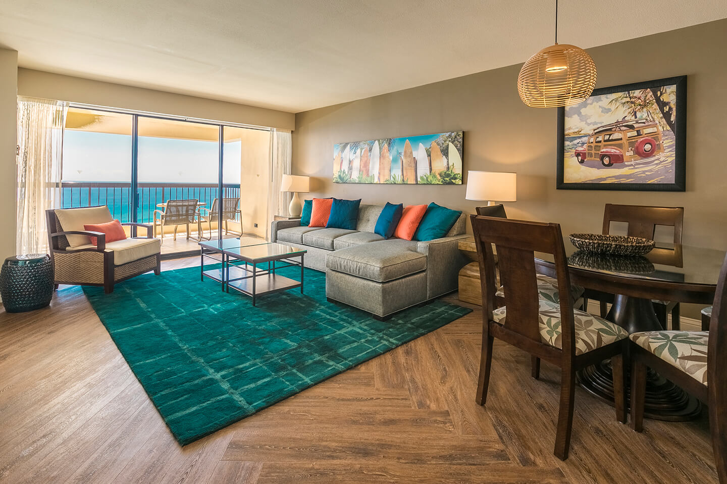 Living room with couch, coffee table, dining area, TV, and balcony with ocean view.
