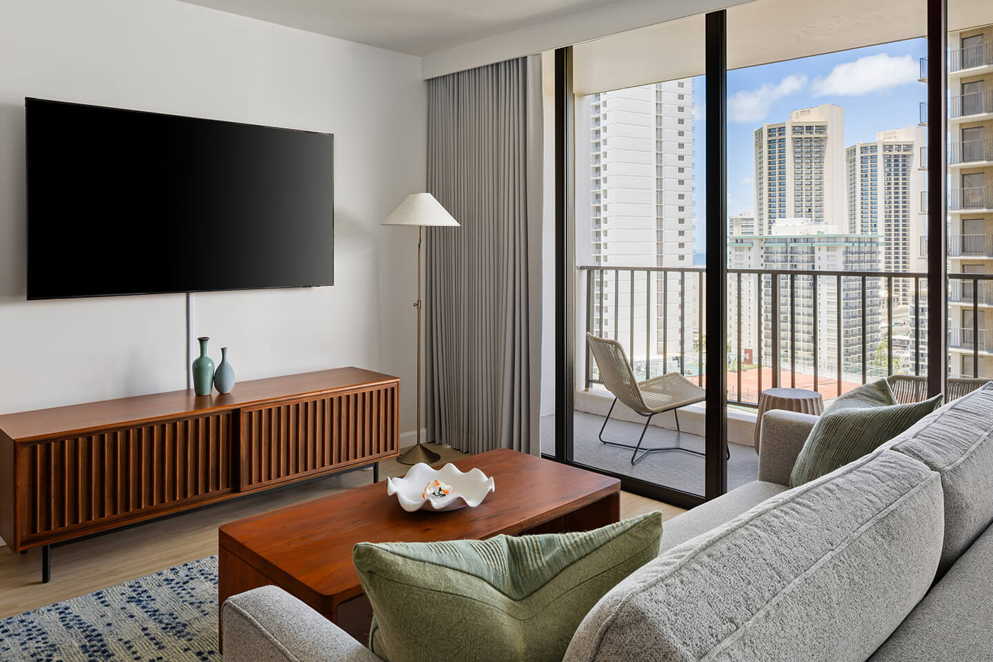 Living room with sliding door to balcony with city view.