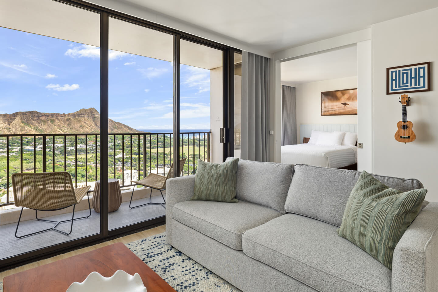Living room with sofa, sliding door to balcony with view of Diamond Head.