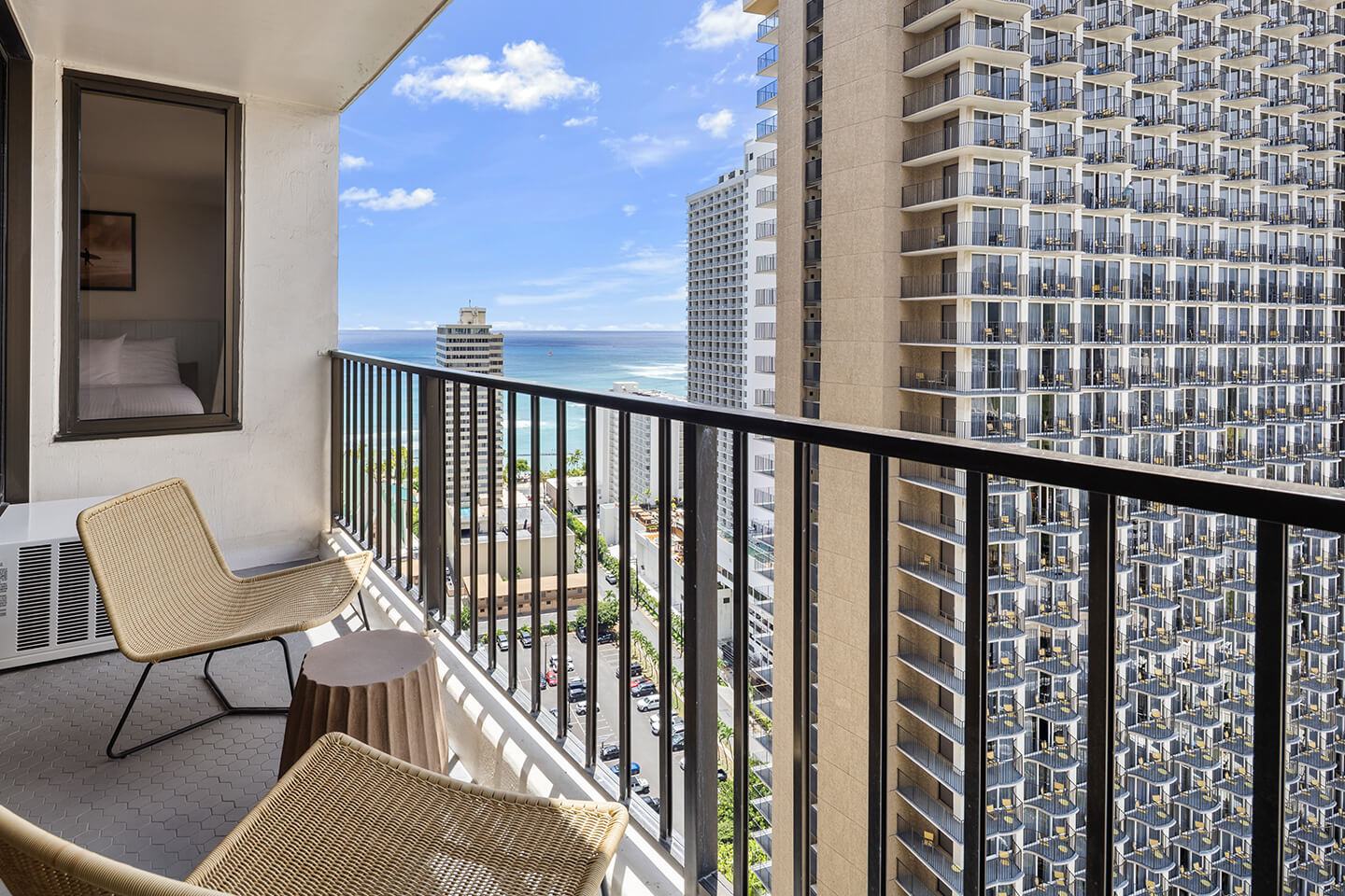 Balcony with chairs and partial ocean view.