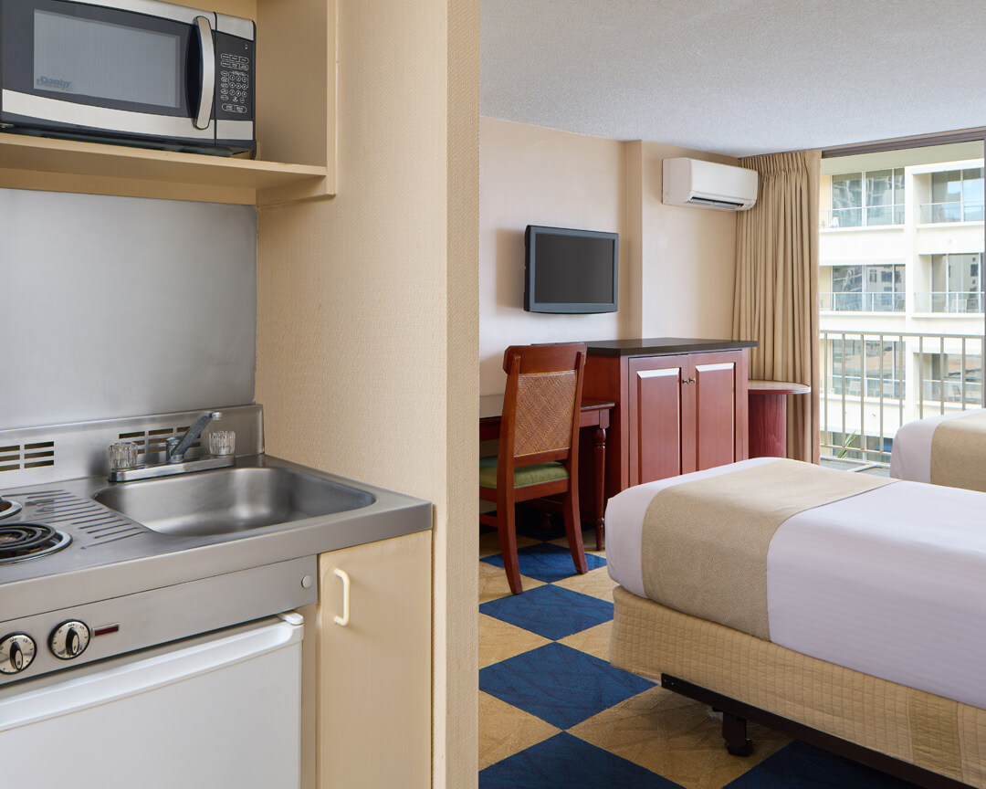 Room with bed, microwave and mini-fridge.