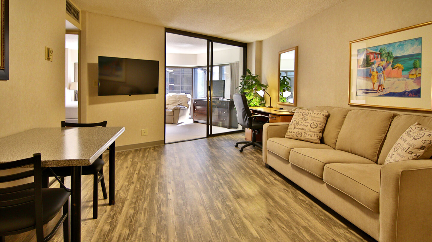 Living area with couch, seating, table, and TV.