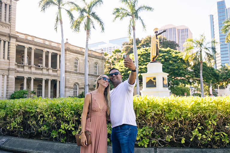 Couple taking selfie photo at Aliiolani Hale in Downtown Honolulu.
