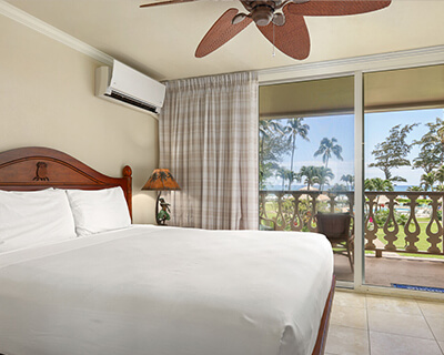 Room with a bed, lamp, and balcony.