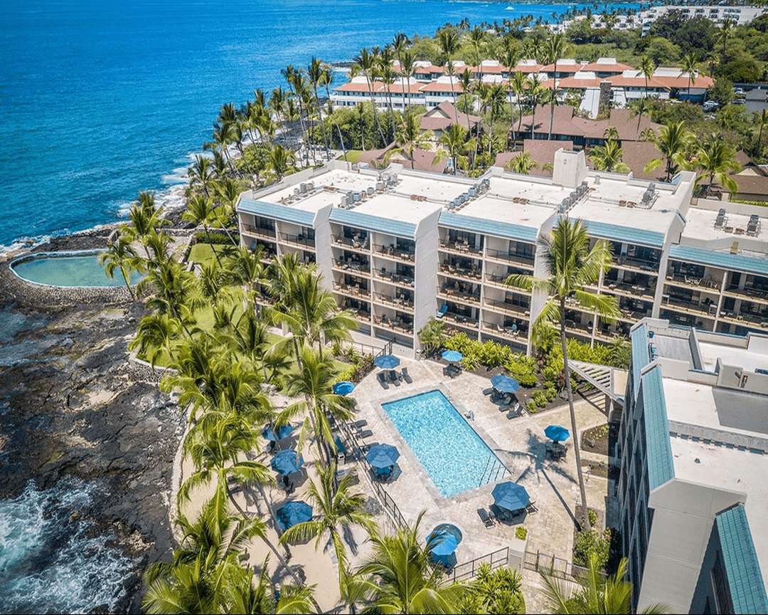 Aerial view of Aston Kona by the Sea including swimming pool and shoreline.