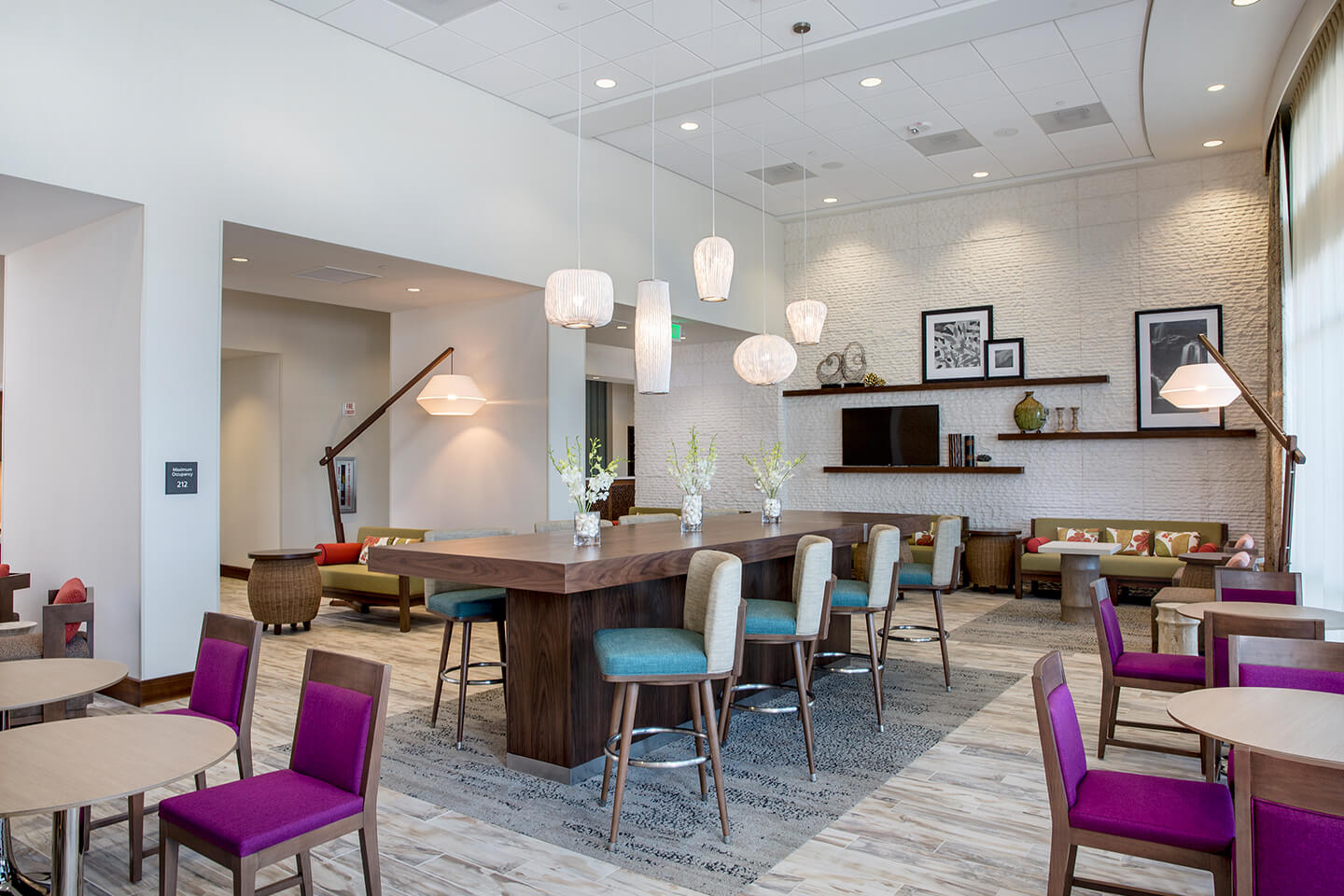 Lobby area with tables, chairs, couch, TV