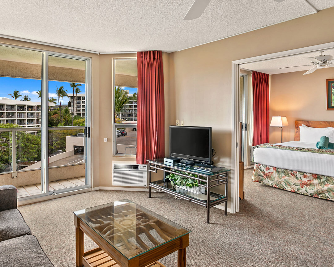 Room with bed and patio with table and seats.