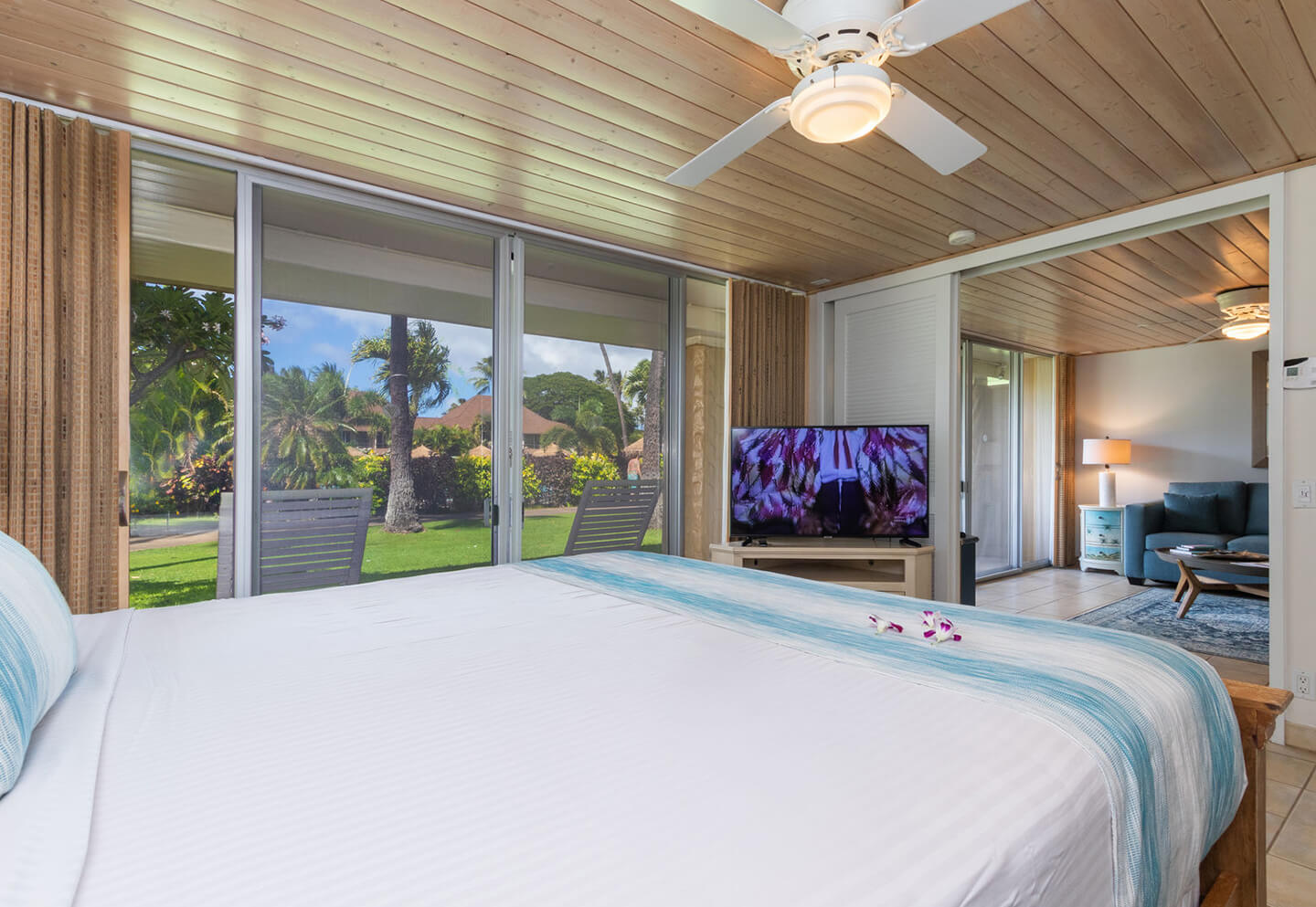Room with a bed, TV, lamps, and patio.
