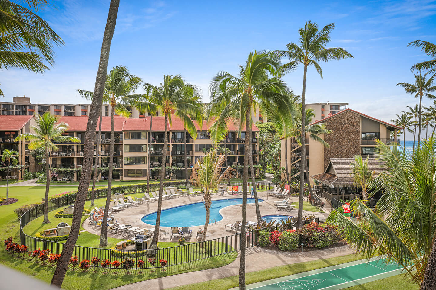 View of the property pool, garden grounds, and shuffleboard court