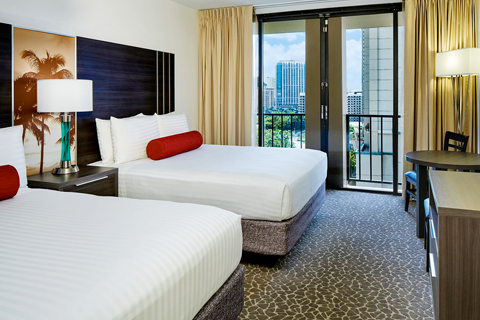 Room with bedding, coffee table, lamp, balcony.