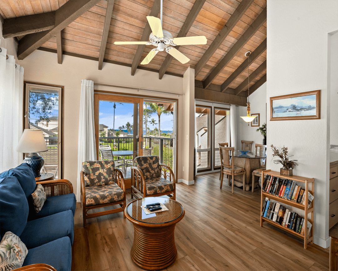 Living area with couch, table, balcony and separate dining area.