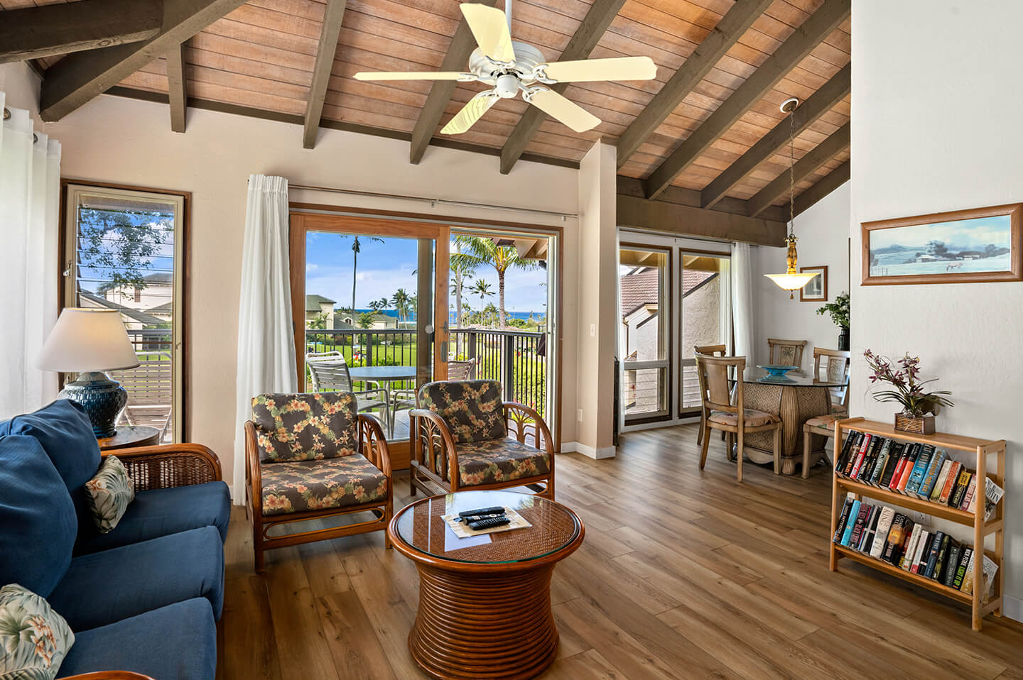 Living area with couches, table, TV, balcony.