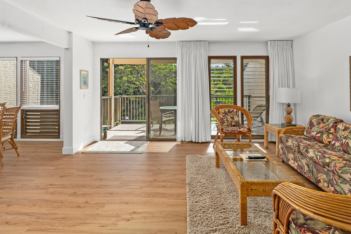 Living room with couch, coffee table, lamp, and balcony.