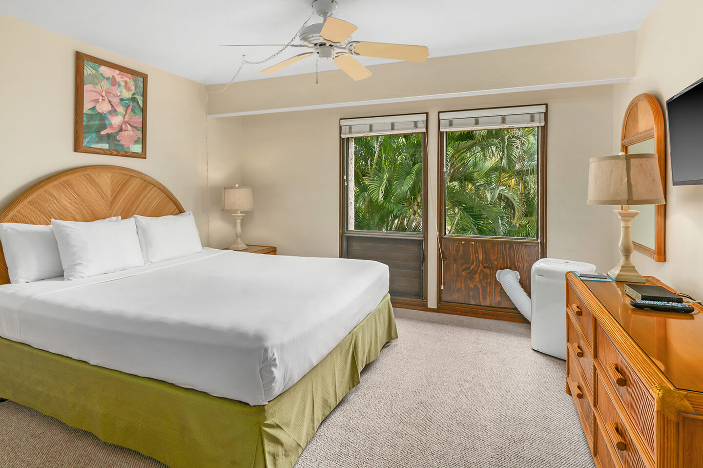 Room with bed, dresser, lamp, TV, and portable A/C unit.