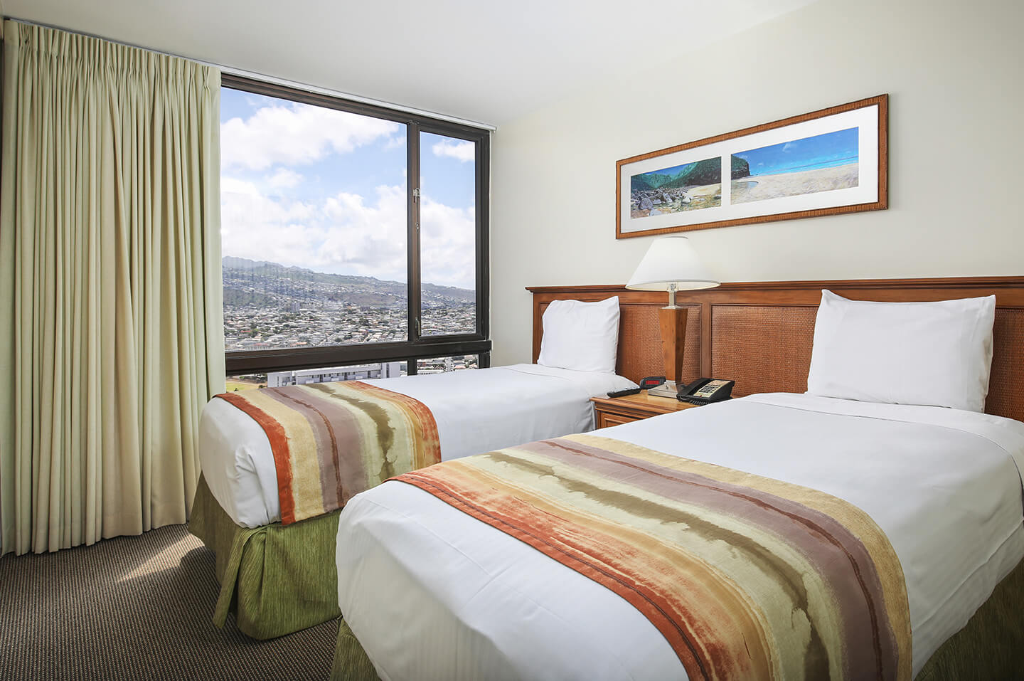 Room with 2 beds and large picture window.