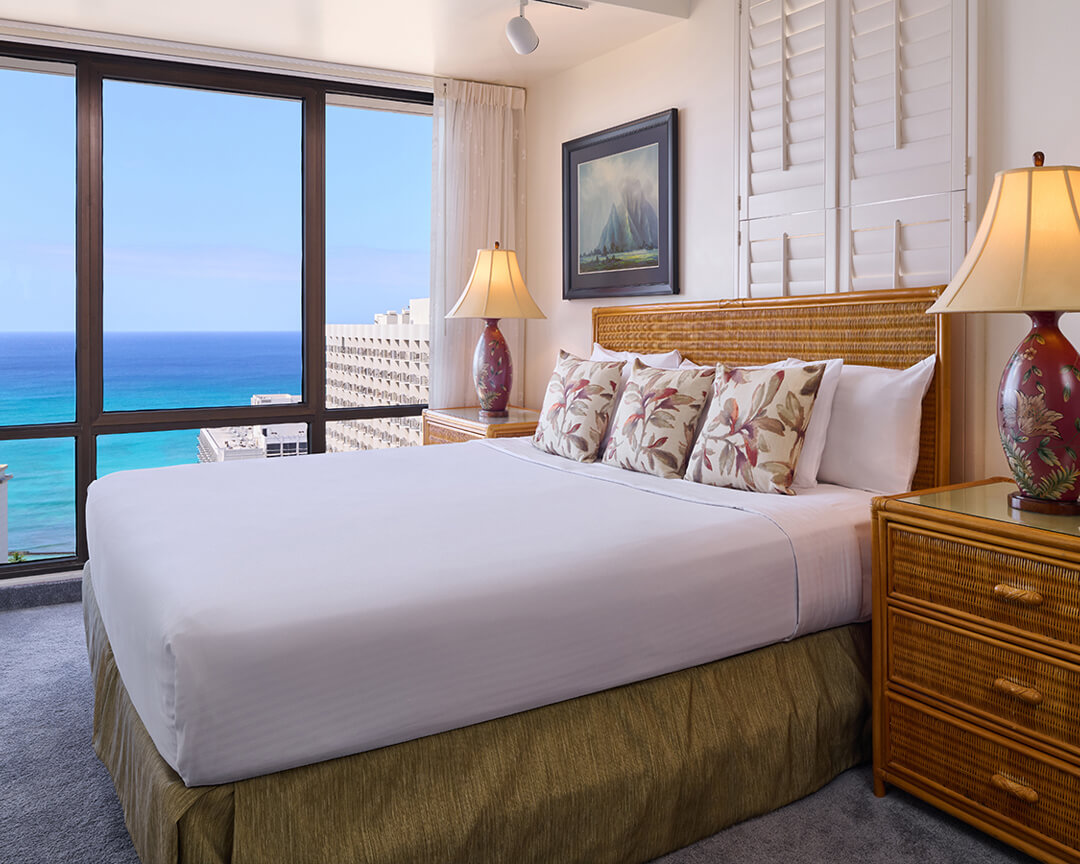 Bedroom with large windows overlooking the ocean.
